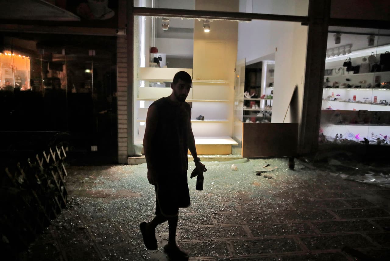 Un hombre camina fuera de una zapatería que fue alcanzada en Holon, cerca de Tel Aviv, por uno de los 
<a href="https://www.univision.com/noticias/mundo/israel-gaza-hamas-misiles-tel-aviv">cohetes lanzados sobre Israel</a> desde la Franja de Gaza, controlada por Hamas.