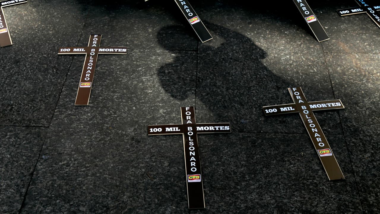 Sindicatos de trabajadores colocaron cruces negras en el suelo que dicen "100 mil muertos, fuera Bolsonaro" frente a la Catedral de Sao Paulo, Brasil.