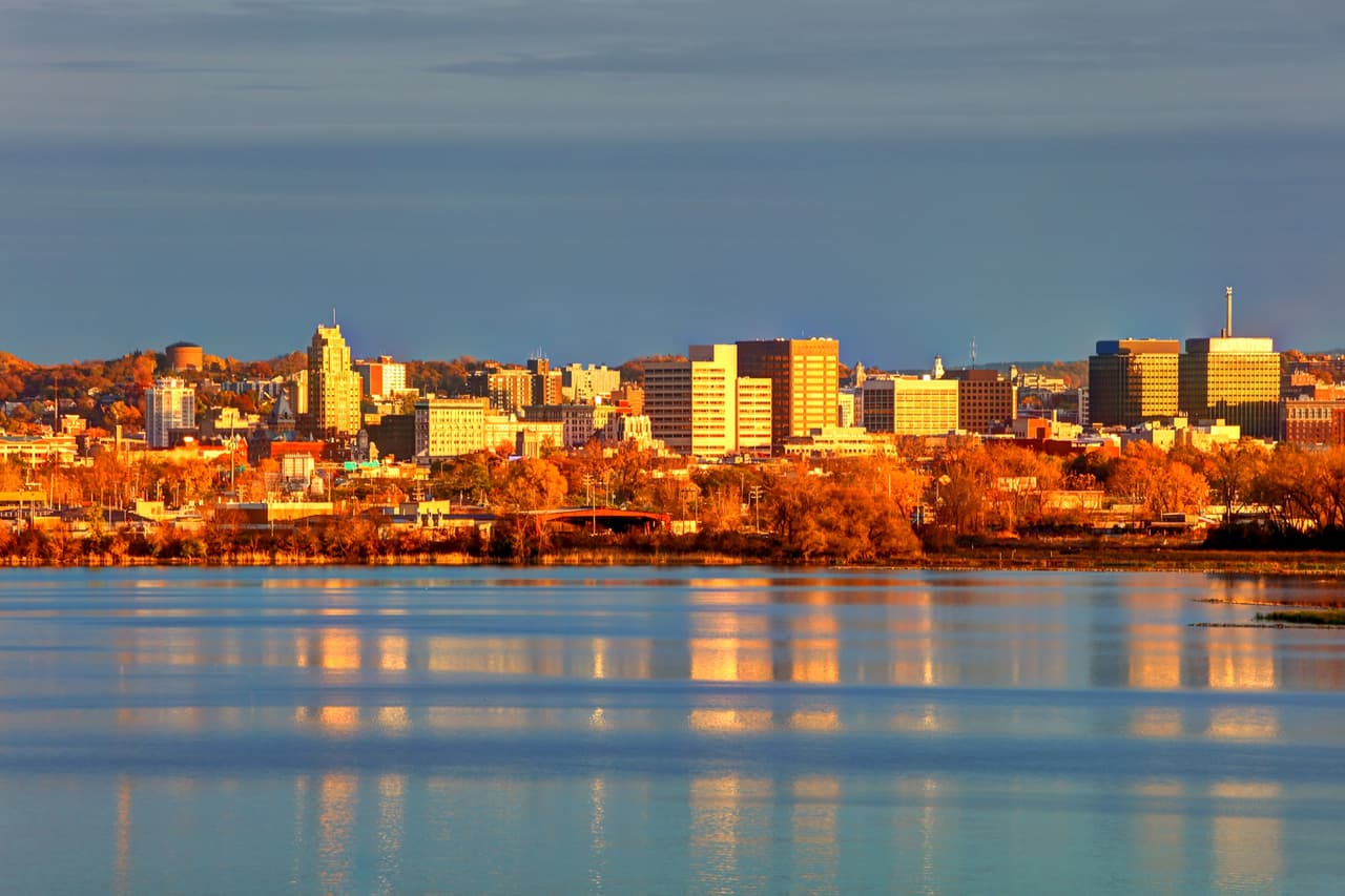 <h2 class="cms-H2-H2">9. Mattydale, Nueva York</h2>
<br>
<br>🏠 
<b>Precio promedio de una vivienda: </b>$128,900
<br>
<br>🏠 
<b>Zona metropolitana: </b>Syracuse, Nueva York
<br>
<br>Este sitio, de unos 6,700 habitantes, se sitúa en los suburbios de Syracuse, Nueva York, y es conocida por haber sido hogar de L. Frank Baum, autor de “El Maravilloso Mago de Oz”. 
<br>
<br>El reporte de Realtor.com señala entre sus ventajas que se sitúa cerca de cines, restaurantes y bares, además de estar a solo 3.6 millas (5.7 kilómetros) del Aeropuerto Internacional Syracuse Hancock. 
<br>