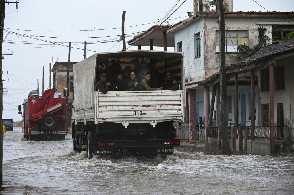 Un camión que transporta miembros del ejército pasa por una calle inundada en Batabano, Cuba, tras el paso del huracán Ian.
