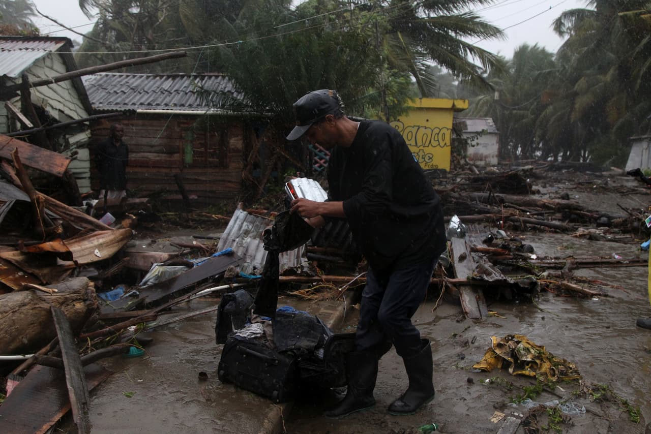Un hombre empaca algo de ropa que recuperó de su hogar afectado por el paso del huracán Irma por el poblado dominicano de Nagua, en República Dominicana, donde más de 5,500 personas fueron evacuados de las zonas de peligro.