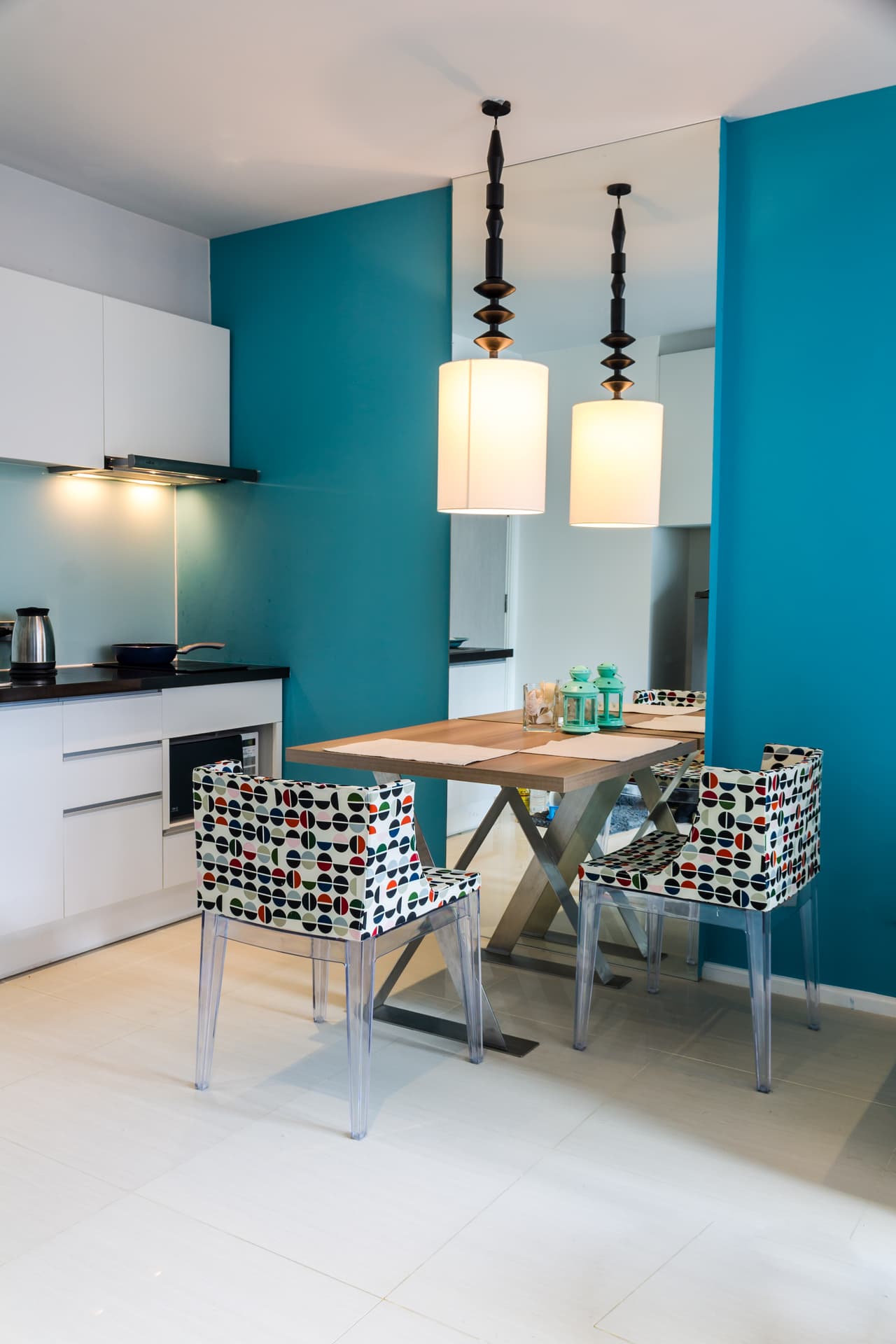 En este caso aunque la mesa es realmente muy pequeña, el espejo en la pared provoca la sensación de amplitud y puedes elegir sillas modernas y llamativas.