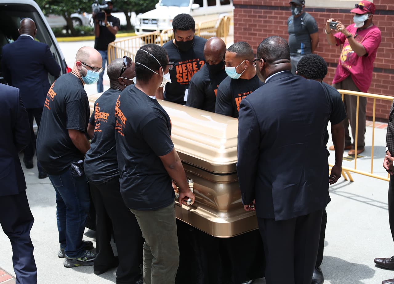 Un grupo de hombres cargan féretros con los restos de Rayshard Brooks para ingresar a la Iglesia Bautista Ebenezer. Brooks fue asesinado el 12 de junio por un oficial de policía de Atlanta después de una lucha durante una prueba de sobriedad en el estacionamiento de un restaurante de Wendy's.