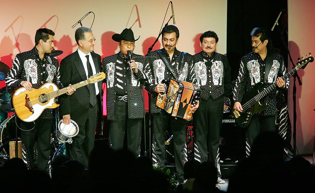 2. 
<b>"Tres Veces Mojado" (1987)</b> 
<br>
<ul>
 <li><b>Por qué es emblemática</b>: Cuenta la historia de alguien que viene desde El Salvador y tiene que cruzar tres países (El Salvador, Guatemala y México) para llegar a Estados Unidos. En cada frontera enfrenta peligros y maltratos.</li>
</ul> 
<ul>
 <li><b>Impacto</b>: Fue de las primeras canciones que mostró que no solo los mexicanos migran a Estados Unidos, sino también gente de Centroamérica que tiene que hacer viajes más largos y peligrosos.</li>
</ul>