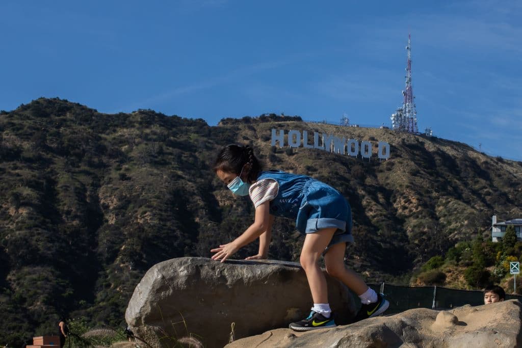 Una pequeña escala una piedra en la zona del Observatorio Griffith , mientras sus padres admiraban las vistas de la ciudad.