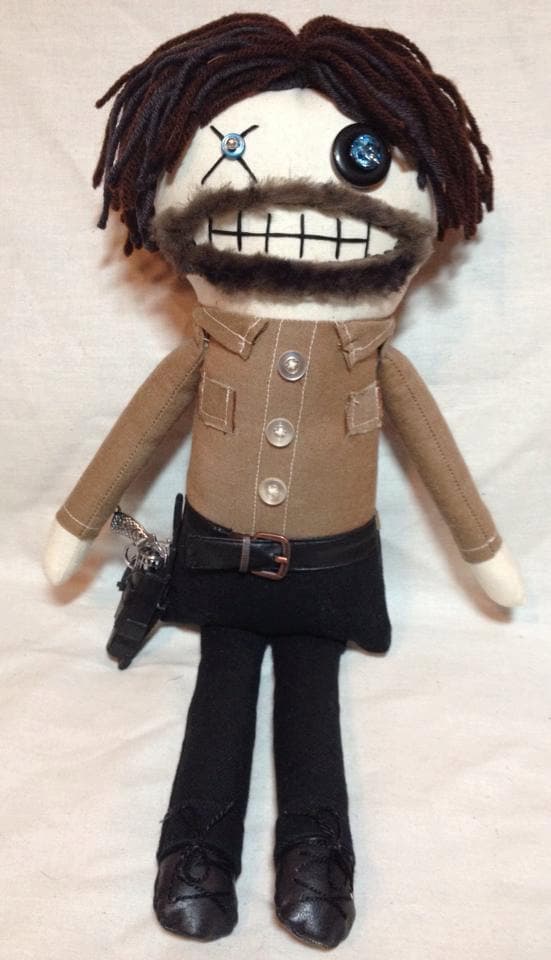 Otra versión de un muñeco zombie de peluche, con un ojo de botón y dientes gigantes.