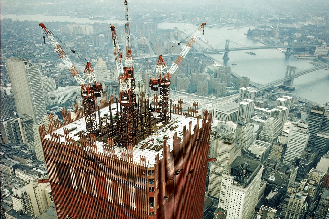 Grúas trabajando en la construcción de la torre norte del World Trade Center de Nueva York, la primera en ser embestida por un avión repleto de gasolina el 
<a href="https://www.univision.com/noticias/20-anos-atentados-9-11" target="_blank">11 de septiembre de 2001</a>. Ese día perdieron la vida en el complejo 2,753 personas, entre ellos 343 bomberos de Nueva York, 23 policías de la ciudad y 37 agentes de la Autoridad Portuaria.
<br>
<br>Si los edificios no hubieran colapsado la tragedia habría sido mucho menor. En estos 20 años los expertos han debatido sobre las causas de los derrumbes.
<br>