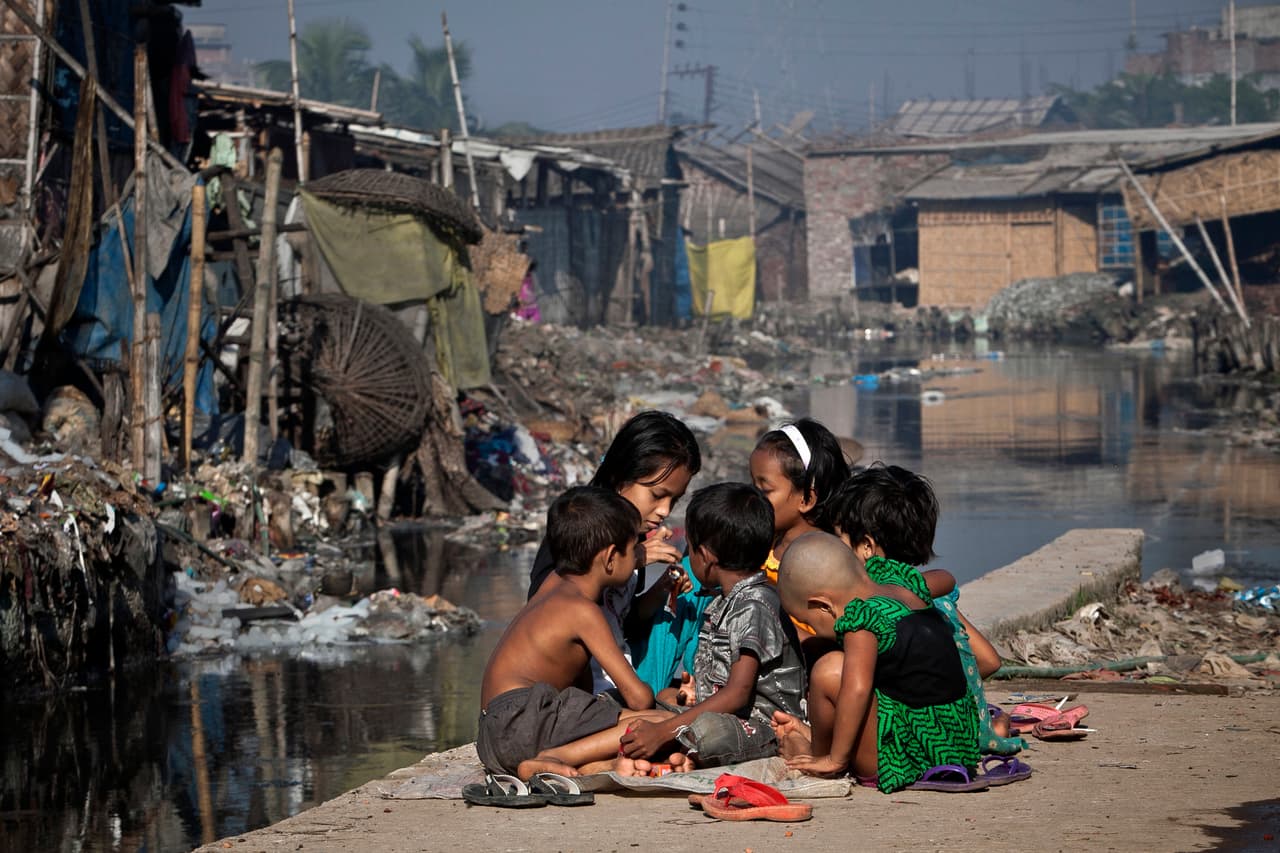 Niños juegan fuera de su casa, al lado de un canal contaminado por la industria de cuero y que desemboca en el río Buriganga en Bangladesh. Se estima que este sitio recibe unos 22,000 litros cúbicos de residuos tóxicos al dia. La industria del cuero exporta millones de dólares a todo el mundo, incluyendo los EEUU y Europa. La fotografía es de noviembre de 2013.