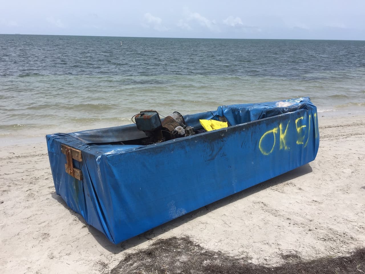 A Cuban rafter boat made from styrofoam and blue tarp and equipped with a rusty old tractor motor washed up on a Florida beach June 5, 2016