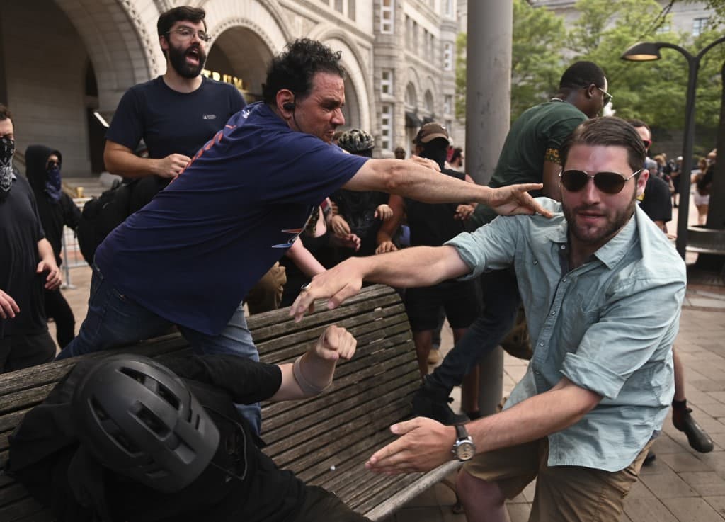 Integrantes de Antifa (ultraizquierda) y de Proud Boys (ultraderecha), se enfrentaron en sangrientas batallas callejeras el mes pasado en Portland, Oregón y este sábado tuvieron acaloradas discusiones.
<br>
<br>En la imagen, se aprecia un intercambio violento entre miembros de ambos grupos al finalizar la manifestación, cuando un ultraderechista empujó a un antifascista de un banco.