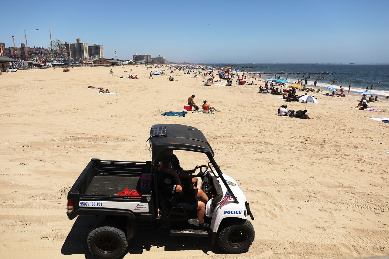 Un vehículo de la policía realiza un patrullaje en la playa de Coney Island.