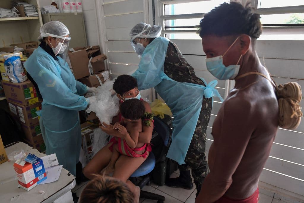Oficiales médicos del ejército brasileño toman muestras de sangre de un bebé de la etnia Yanomami en Alto Alegre, en el estado de Roraima en Brasil el 1 de julio de 2020.