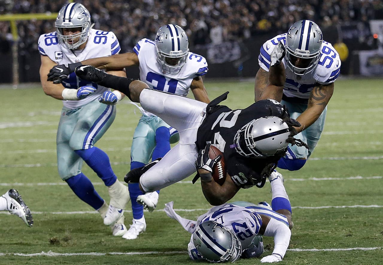 Oakland Raiders running back Marshawn Lynch (24) is tackled by Dallas Cowboys defenders during the second half of an NFL football game in Oakland, Calif., Sunday, Dec. 17, 2017. (AP Photo/Ben Margot)