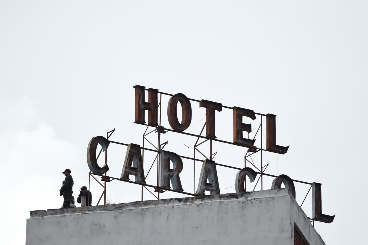 Las fuerzas de seguridad vigilan desde el techo de un edificio.