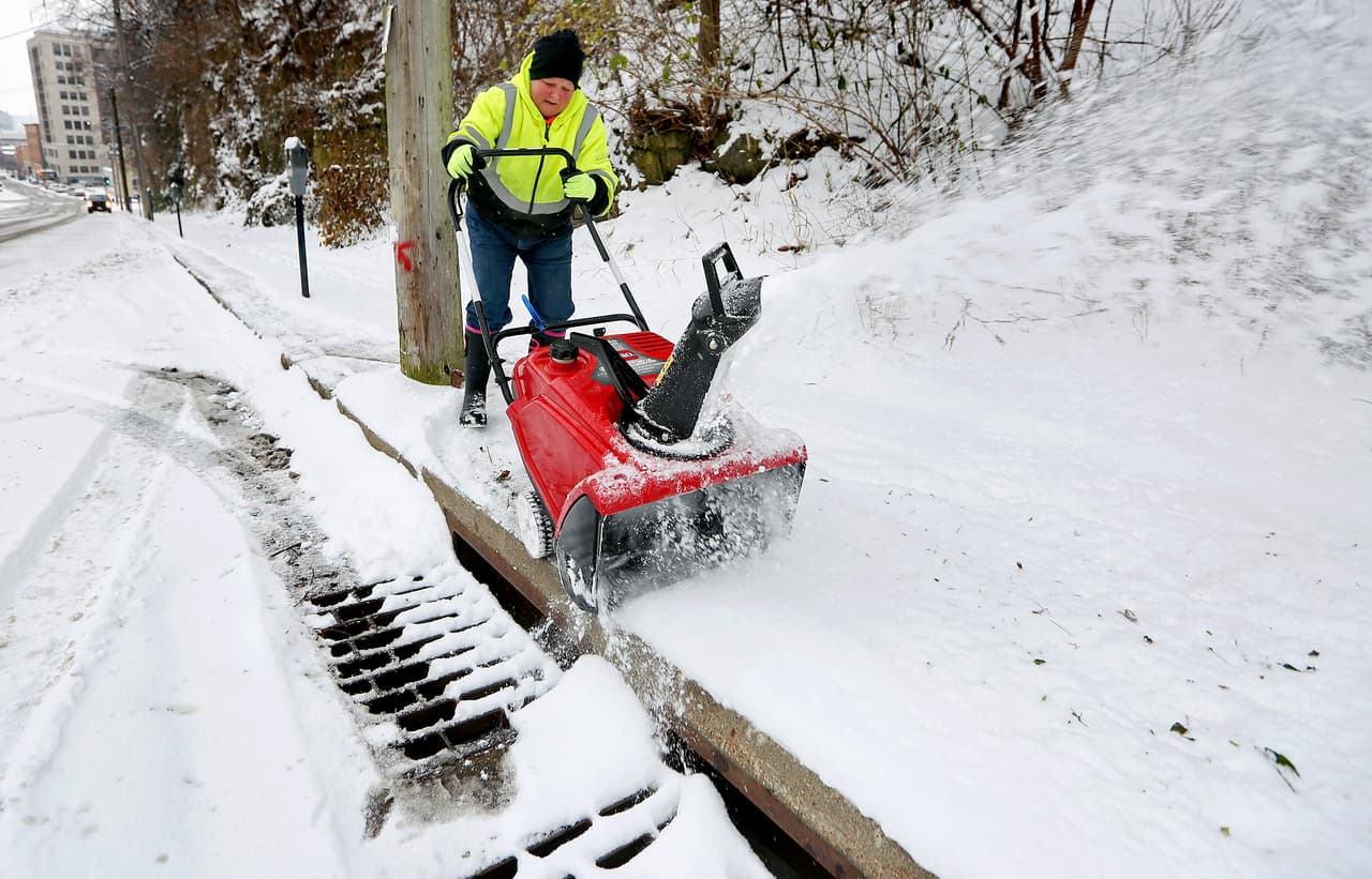 El empleado de la ciudad de Dubuque, Charlie Leirmoe-Kaiser, limpia la nieve de la acera a lo largo de la Octava Calle en Dubuque, Iowa.