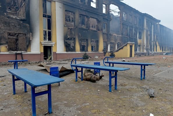 El cuerpo de un soldado ruso yace en medio del patio de una escuela destruida en Járkov.