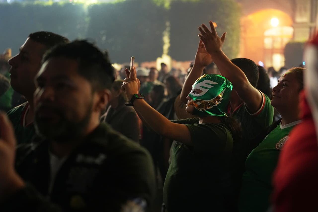 Un asistente luce una máscara de lucha libre mientras participa en los festejos patrios en el Zócalo de Ciudad de México.