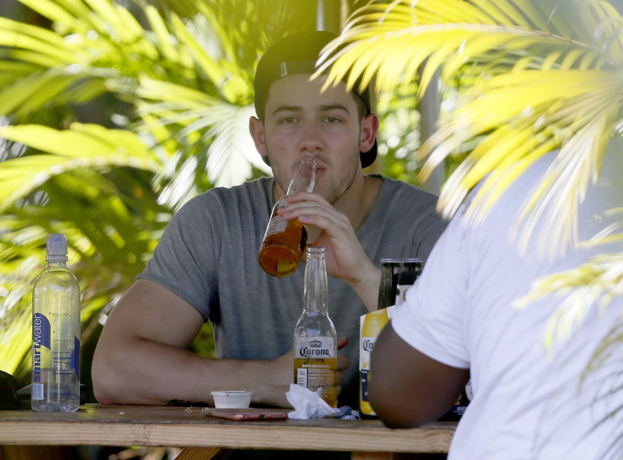 Nick Jonas en Hawaii gozando de una cerveza.