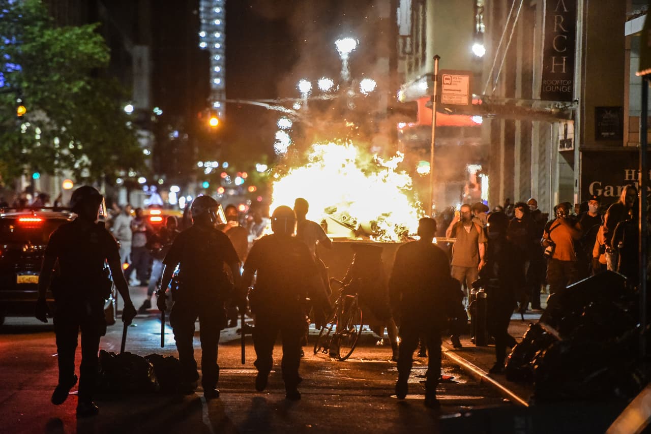 Los manifestantes incendiaron un contenedor de basura durante la manifestación de este domingo 31 de mayo de 2020 en la ciudad de Nueva York, que se unió a las protestas ocurridas en varias ciudades en Estados Unidos tras la muerte de Floyd.