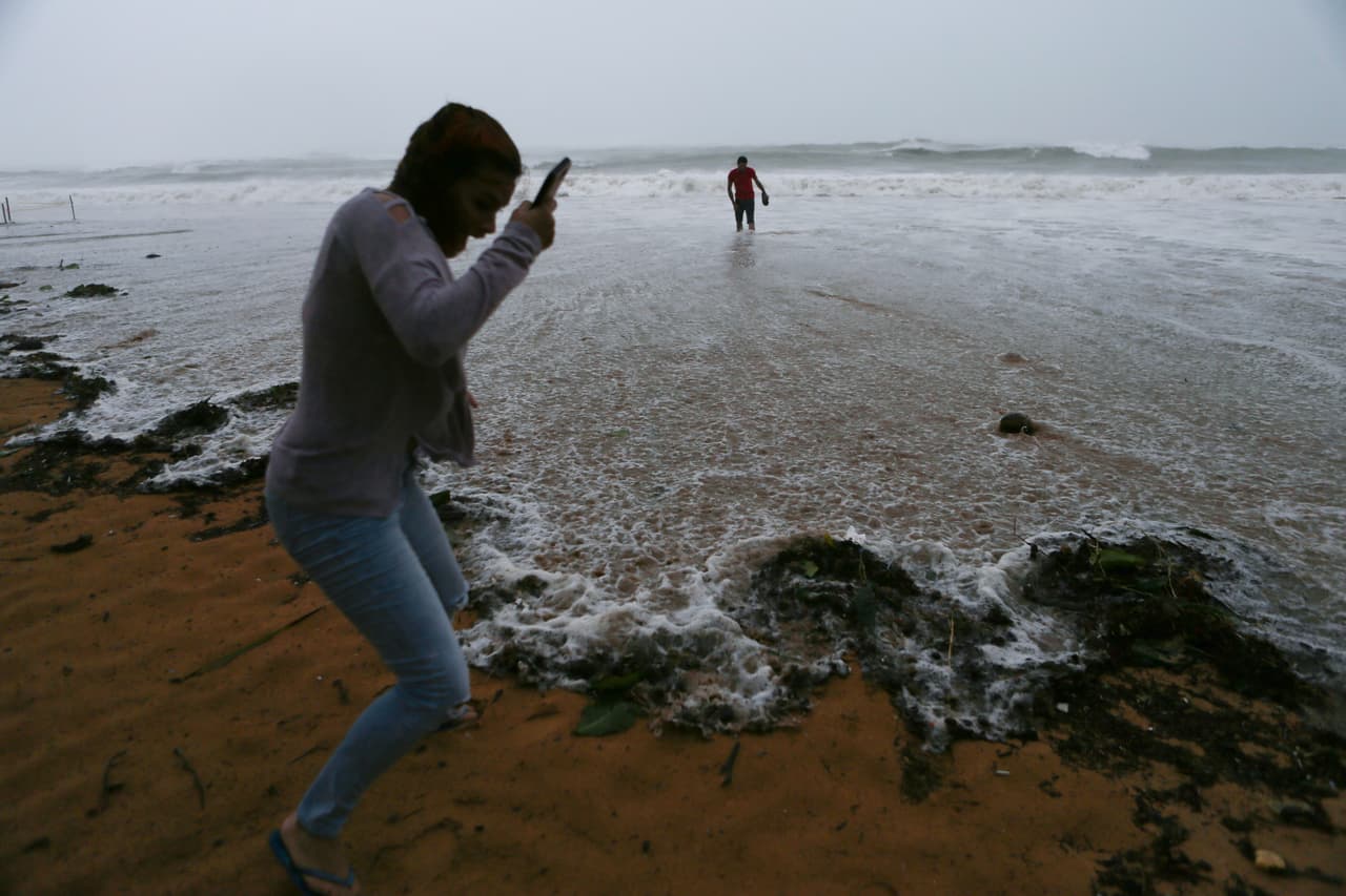 Personas caminan en la orilla del mar en Loquillo, al noreste de Puerto Rico.