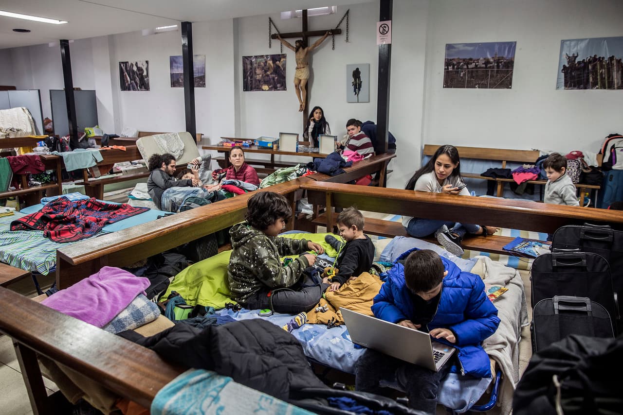 Inside the church, pews separate beds to accommodate asylum-seeking families.