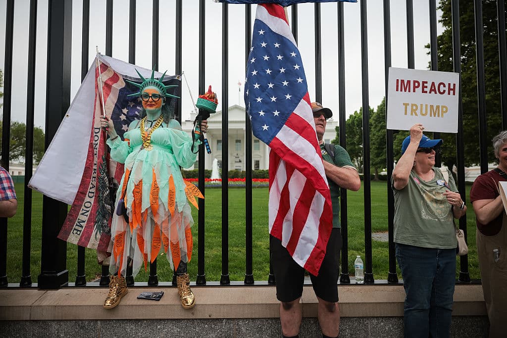 <b>Protestas contra el autoritarismo</b>: Una manifestante porta una pancarta que dice "juicio político a Trump" frente a la Casa Blanca en Washington. En diversas ciudades de EE.UU., se realizan manifestaciones en contra de lo que se percibe como amenazas a los principios democráticos de la nación, pidiendo la defensa de la libertad y la justicia.