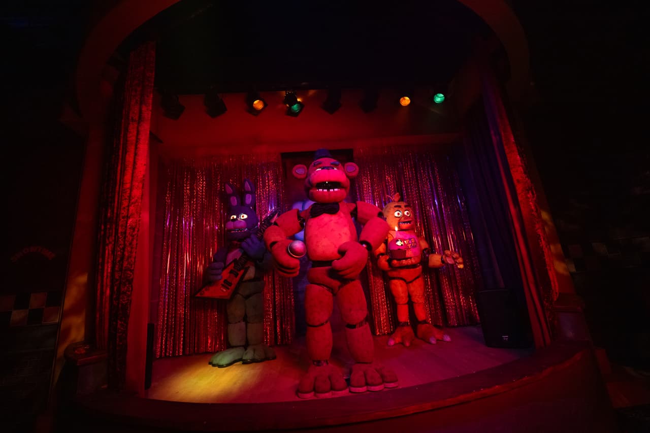 <b>Five Nights at Freddy’s -</b> Los visitantes exploran la Pizzería Freddy Fazbear, donde animatrónicos inquietantes cobran vida y persiguen a los visitantes, sumergiéndolos en un mundo donde lo familiar se convierte en terror constante.