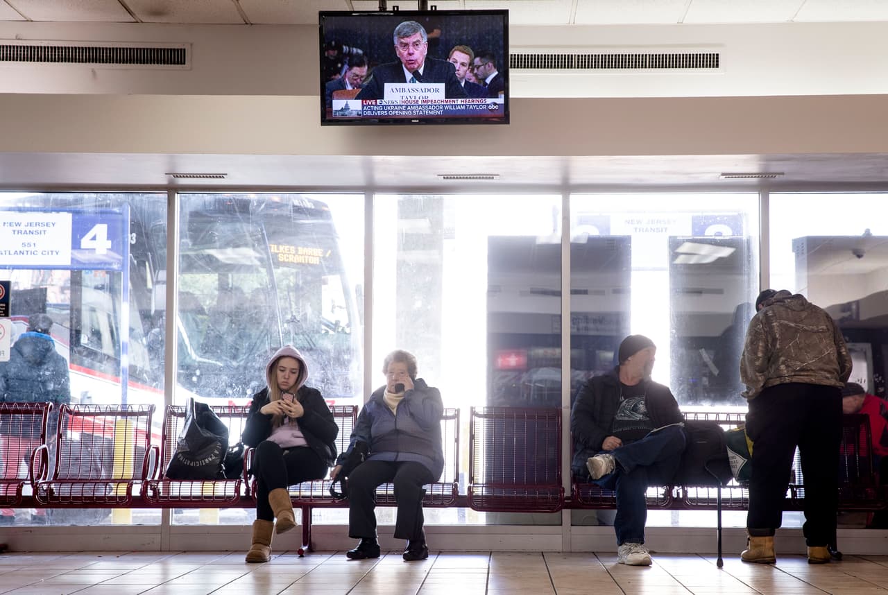 Los pasajeros que esperan en una estación de autobuses en Philadelphia ven la transmisión de las declaraciones de William Taylor al Comité de Inteligencia. Adam Schiff, presidente de esa comisión inauguró la sesión y preguntó de inmediato si el presidente utilizó su cargo para presionar a las autoridades en Ucrania para beneficio político.