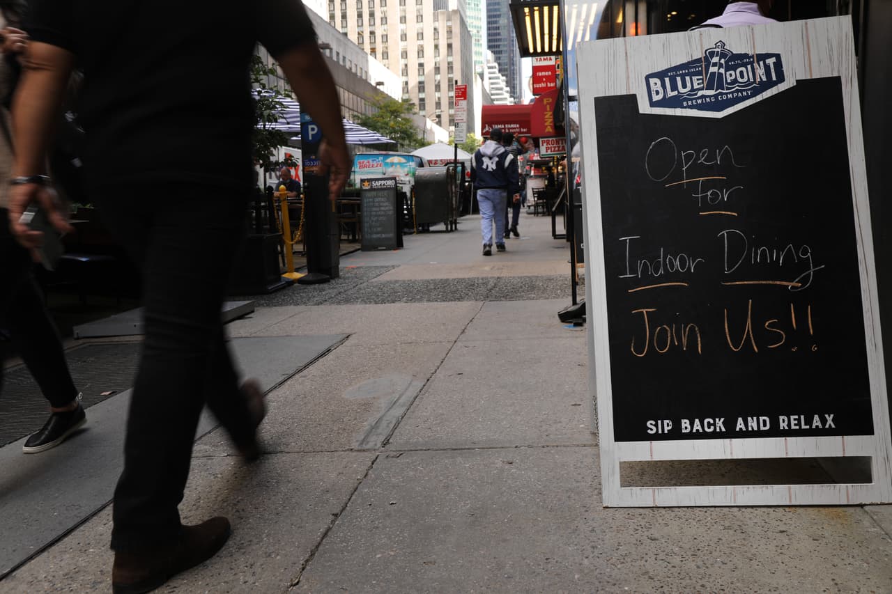 Un letrero anuncia comidas en interiores a lo largo de una calle de Manhattan.