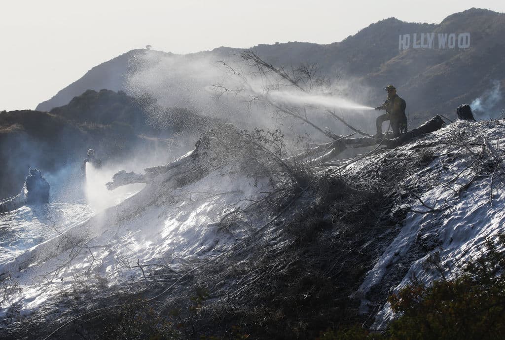 Bomberos rocían espuma contra incendios para aliviar las llamas en el Griffith Park.