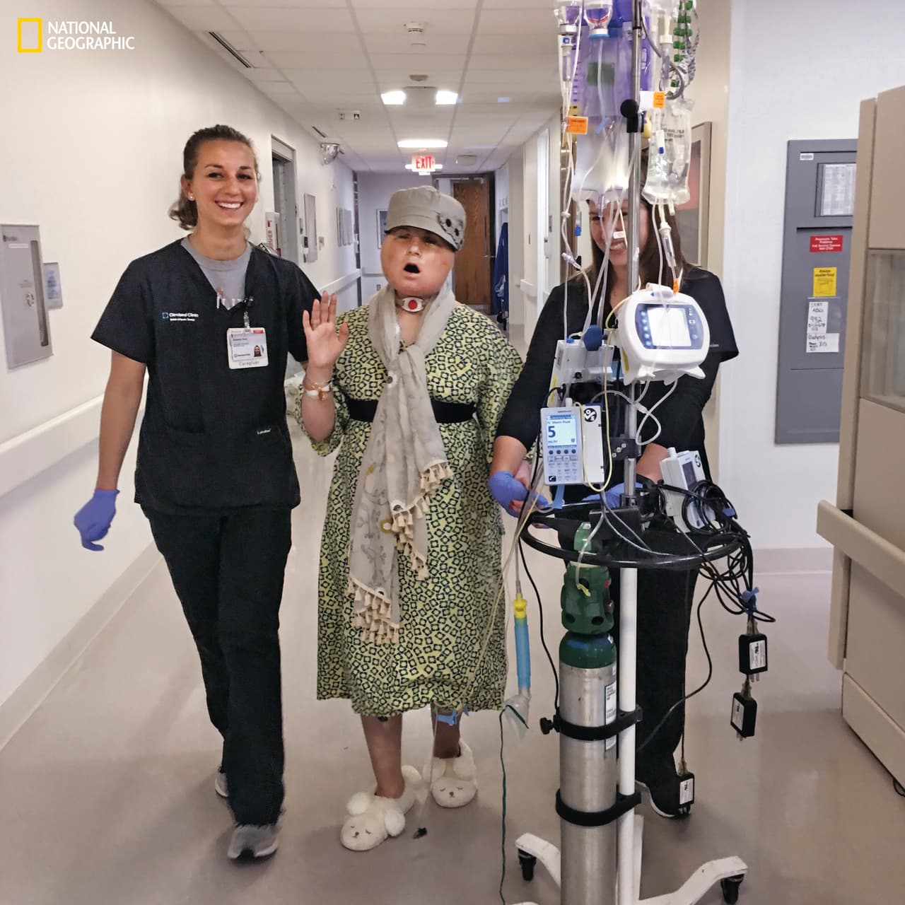 Veinte días después del trasplante de Katie, en una de sus caminatas diarias en los pasillos. Katie canta mientras hace ejercicios con la fisioterapeuta Becky Vano (a la izquierda) y la estudiante de fisioterapia Nicole Bliss. Antes del trasplante, Katie tuvo que aprender a caminar de nuevo para vencer la espasticidad en sus extremidades ,causada por la lesión en su cerebro. Después del trasplante, tuvo que comenzar de nuevo con el fortalecimiento de sus piernas.