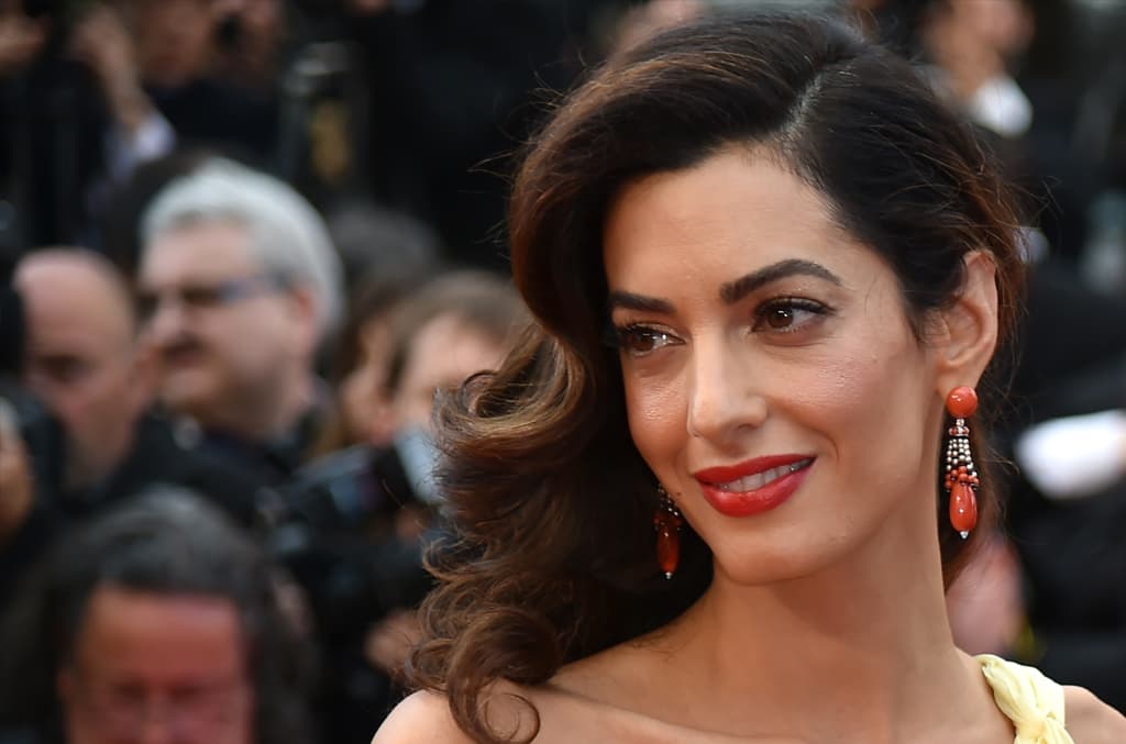No es ninguna sorpresa el poder que tiene Amal Clooney de apoderarse de la alfombra roja. La abogada optó por llevar el pelo con raya de lado y ondas ligeramente marcadas. Los labios en tono rojo es el punto central de su maquillaje. Lo que le aprendemos es la forma en la que lleva el maquillaje en la piel de la cara, pues la base de maquillaje y el blush se ven ligeros. Las cejas bien definidas y pobladas, también son un sello de Amal.