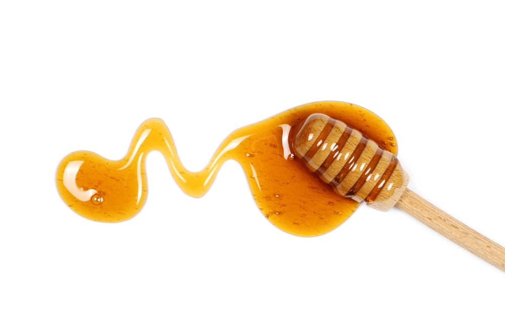 Llena tus dedos con mucha miel y dibuja con ellos muy claro y abundante un corazón grande en la superficie o pedazo de la madera.