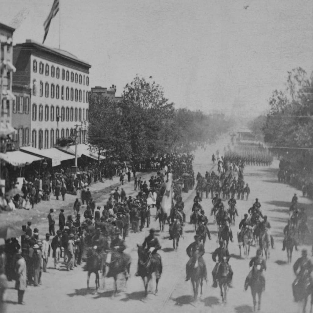 La gente observa a soldados a caballo, seguidos por los que iban a pie, desfilar por la Avenida Pensilvania en Washington, durante la "Gran Revista de los Ejércitos" del 23 al 24 de mayo de 1865. (Matthew Brady/Biblioteca del Congreso vía AP)