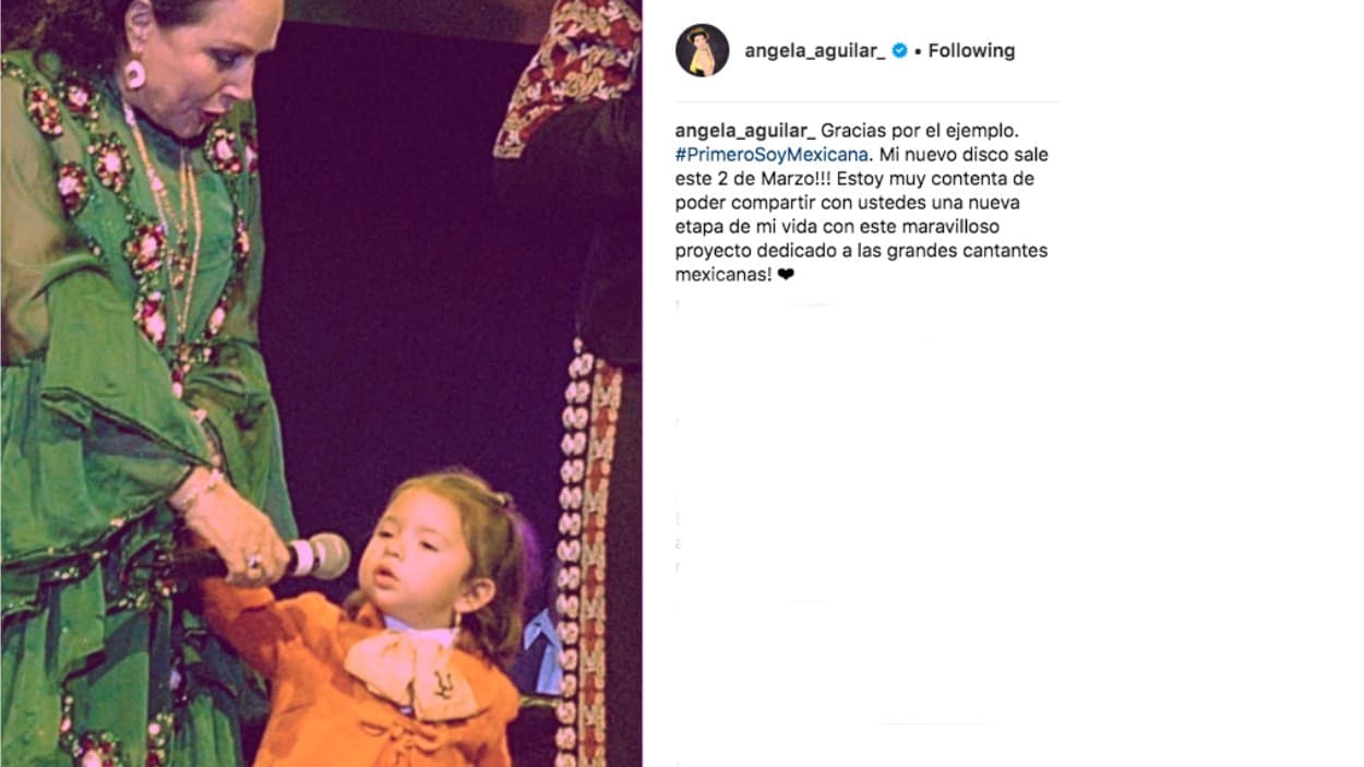 "Gracias por el ejemplo", escribió la cantante Ángela Aguilar junto a esta imagen que la muestra muy pequeña en el escenario mientras su abuela le sostiene el micrófono.