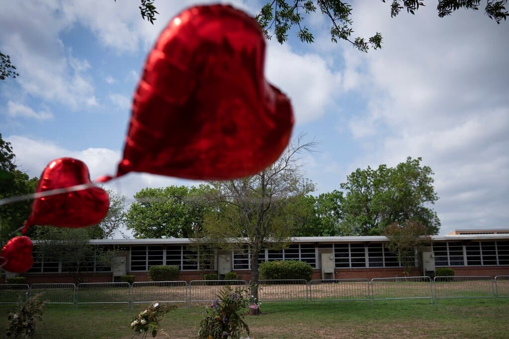 Globos rojos en forma de corazón frente a la Escuela Primaria Robb. Jimmy Lucas, presidente de la Asociación de Directores de Funerarias de Texas, llevó un auto fúnebre y se ofreció a trabajar como conductor, a colaborar con los servicios o a hacer lo que pudiera, dijo a NBC News.