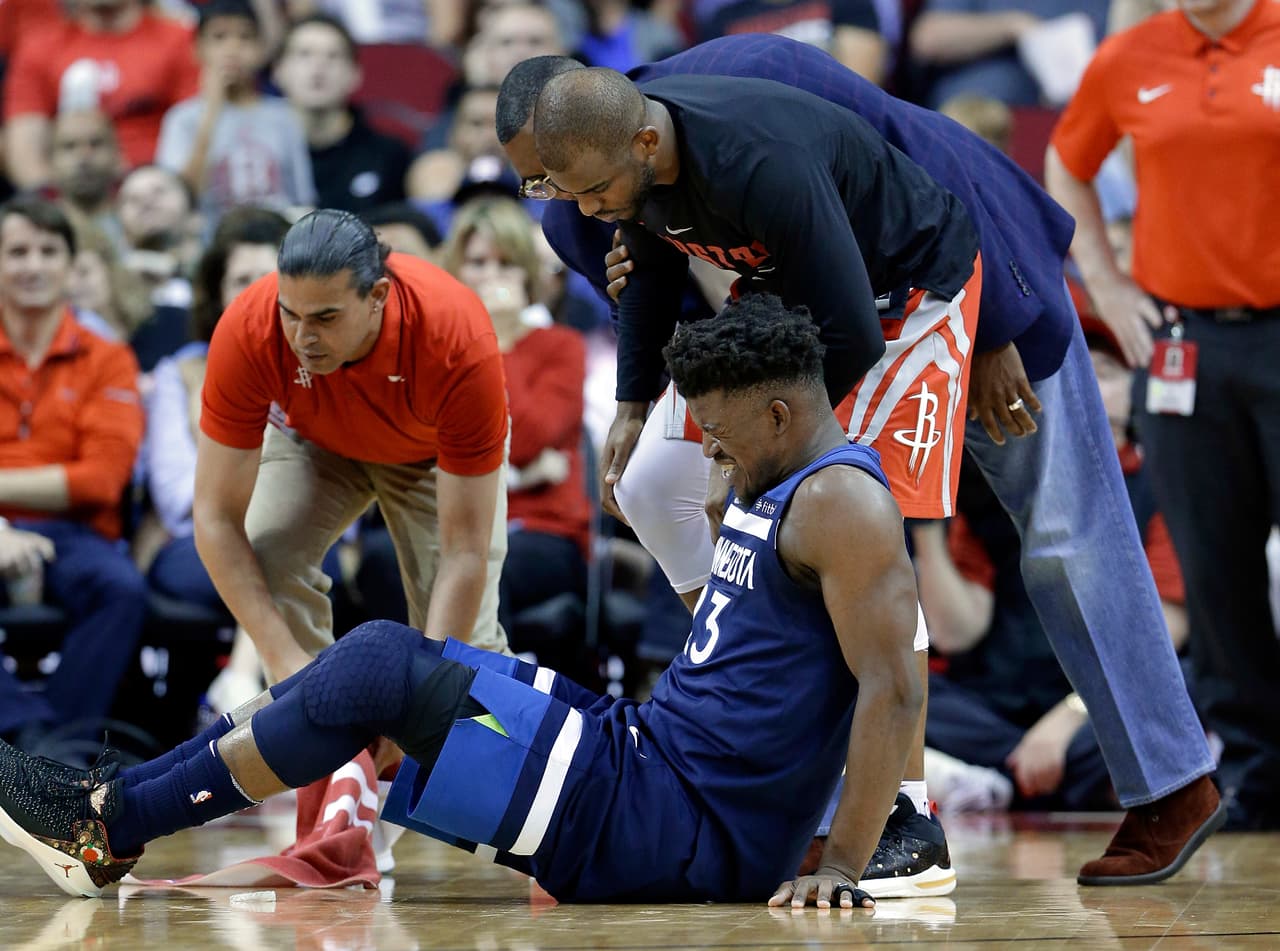Jimmy Butler de los Minnesota Timberwolves reacciona a una lesión de rodilla durante el juego ante los Rockets.