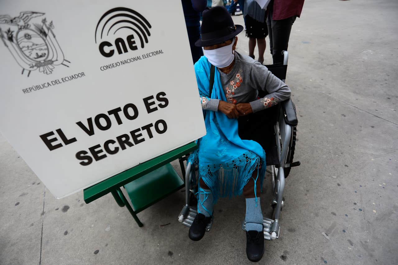 Una mujer en silla de ruedas vota en la Academia "Mayor Pedro Traversari" en Quito.