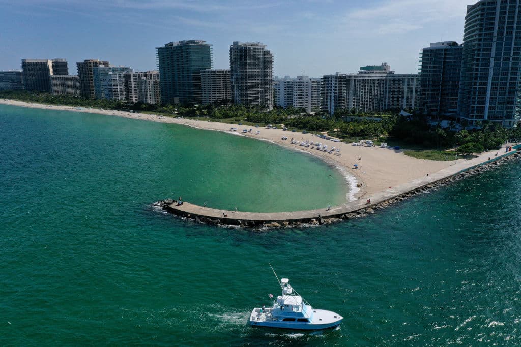 Una hermosa vista de la bahía, un bote y los edificios altos en la costa del sur de la Florida.