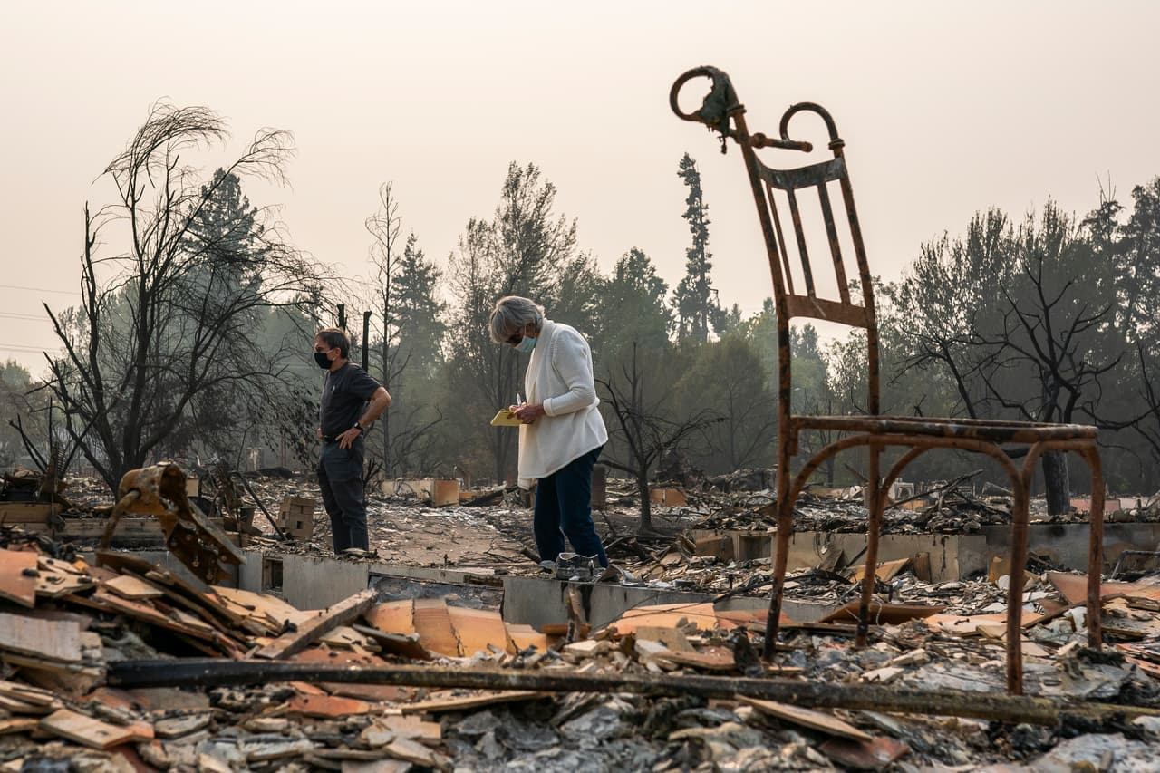 Carol Ovenburg y Gary McKee observan
<b> los restos de su casa quemada en Talent, Oregon.</b> Los líderes de la ciudad estiman que al menos 600 casas se perdieron en el incendio de Almeda mientras quemaba Talent y Phoenix, Oregon.