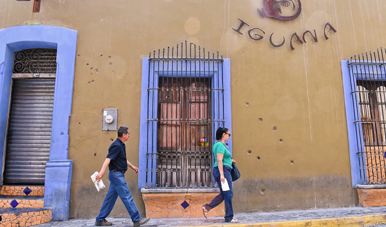 El dueño del Café Iguana dejó las marcas de bala en su muralla, como un testimonio de lo que no debe volver a suceder.