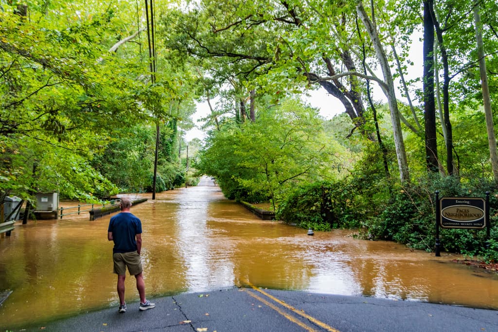 Un hombre mira una carretera inundada en el barrio Paces, Atlanta.