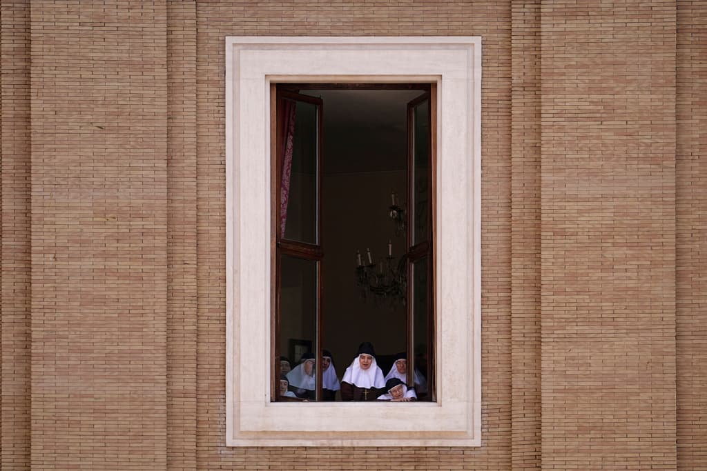 Un grupo de monjas ven el funeral del papa Francisco desde la ventana de un edificio con vista a la plaza de San Pedro.