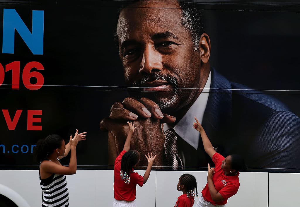 Niños posan frente al bus de campaña del entonces precandidato republicano Ben Carson, agosto 16, 2015, Des Moines, Iowa.