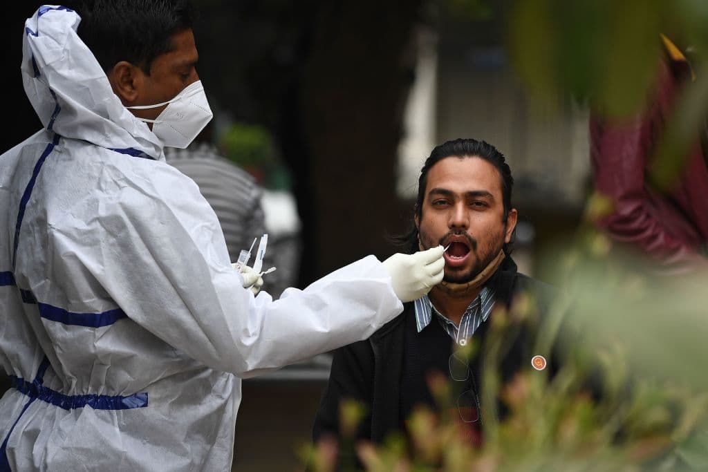 Un trabajador de la salud toma una muestra para una prueba de coronavirus a un hombre en Nueva Deli, capital de India.