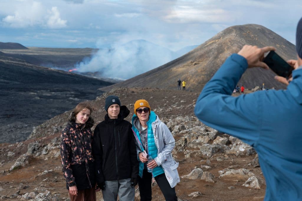 Hanna-Loore Lemmiksoo, Oliver Lemmiksoo y Margit Lemmiksoo, tres turistas de Estonia, posan para una foto con el volcán de fondo.