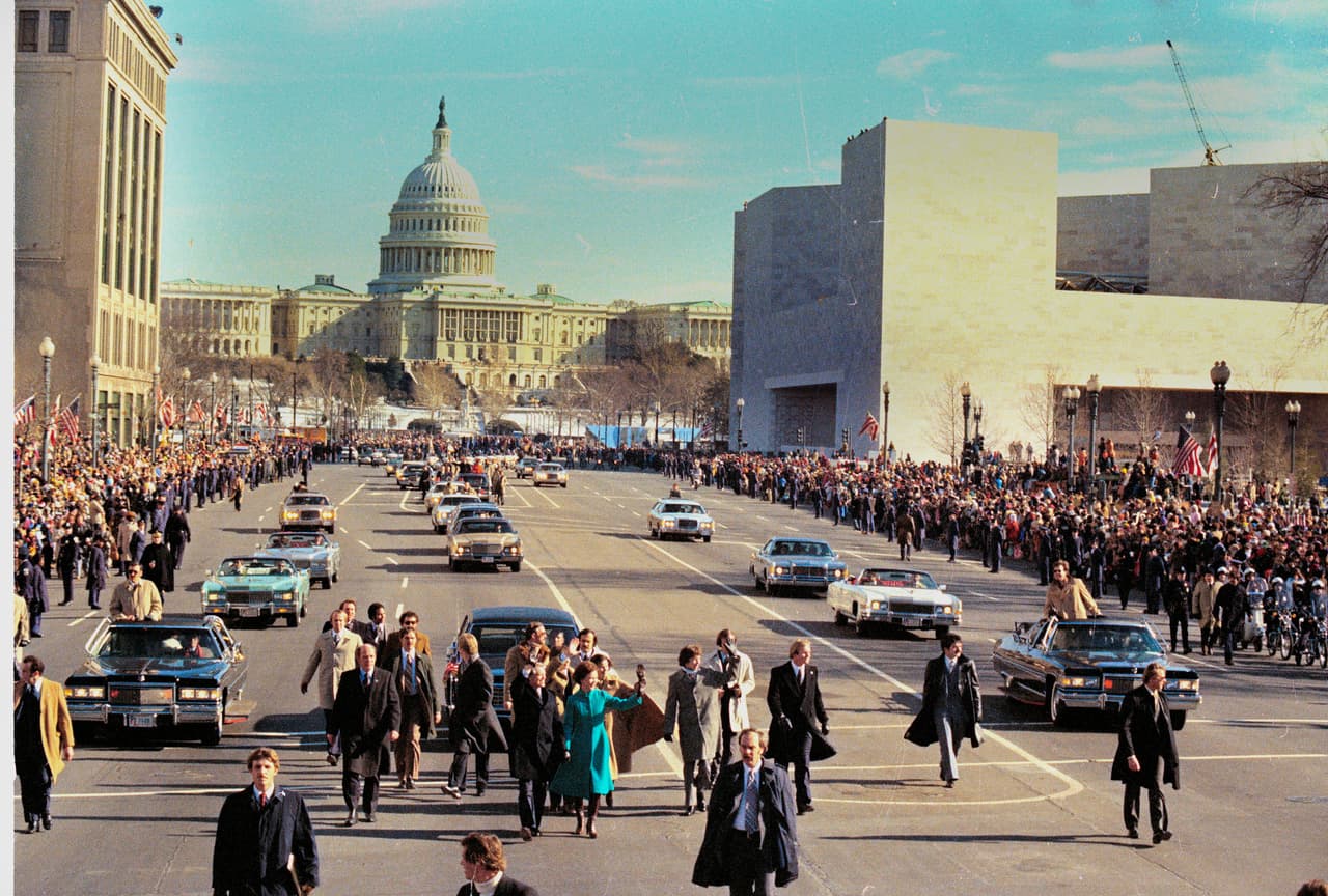 Jimmy Carter (centro a la izquierda) y la primera dama Rosalynn Carter caminan de la mano por la avenida Pennsylvania durante el desfile inaugural en Washington DC, el 20 de enero de 1977.