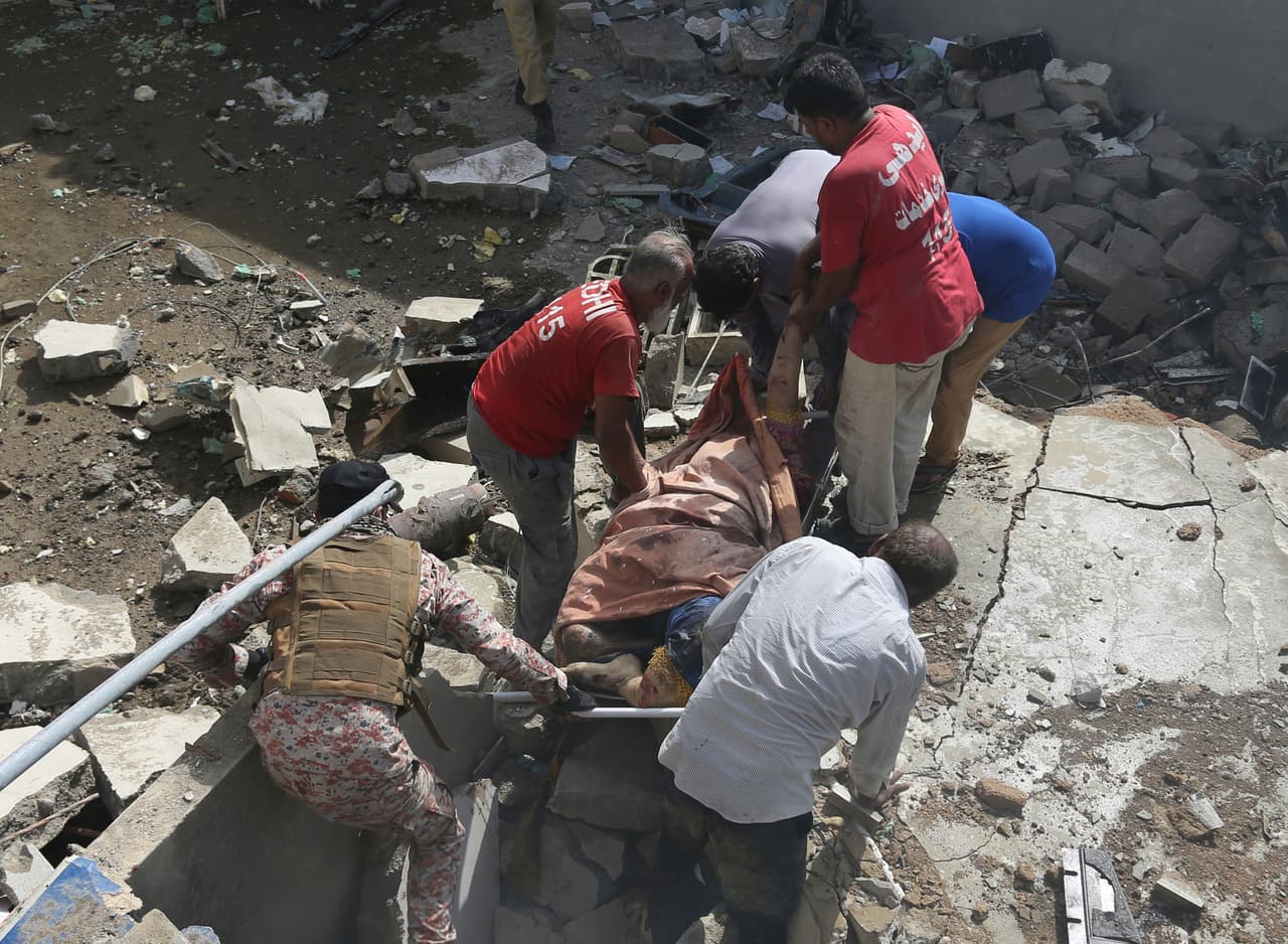 Personal de emergencias buscando a las víctimas del accidente registrado en una zona residencial de Karachi, en el sur de Pakistán.
