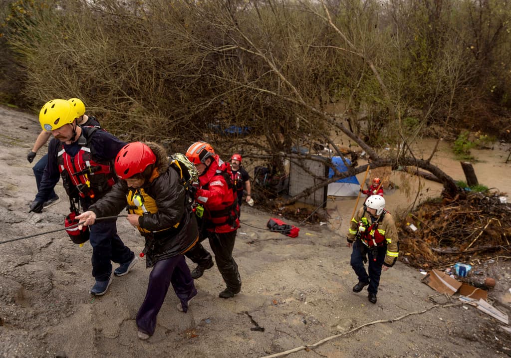 Con una cuerda y la guía profesional de los Bomberos de San Bernardino, la inundación se convirtió para estos indigentes en una historia de vida.