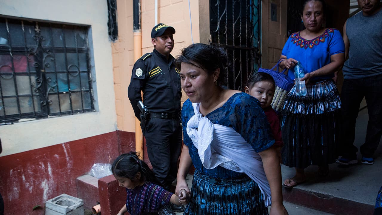 Una mujer y sus hijos salen de un sitio de votación después de emitir su voto, en Chinautla, Guatemala, este domingo. Las autoridades comentaron sobre la baja participación electoral. Una posible razón: la lluvia. Pero sobre todo la falta de entusiasmo por los candidatos.